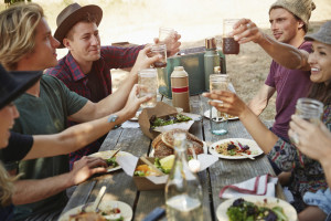 Friends eating at picnic table in park